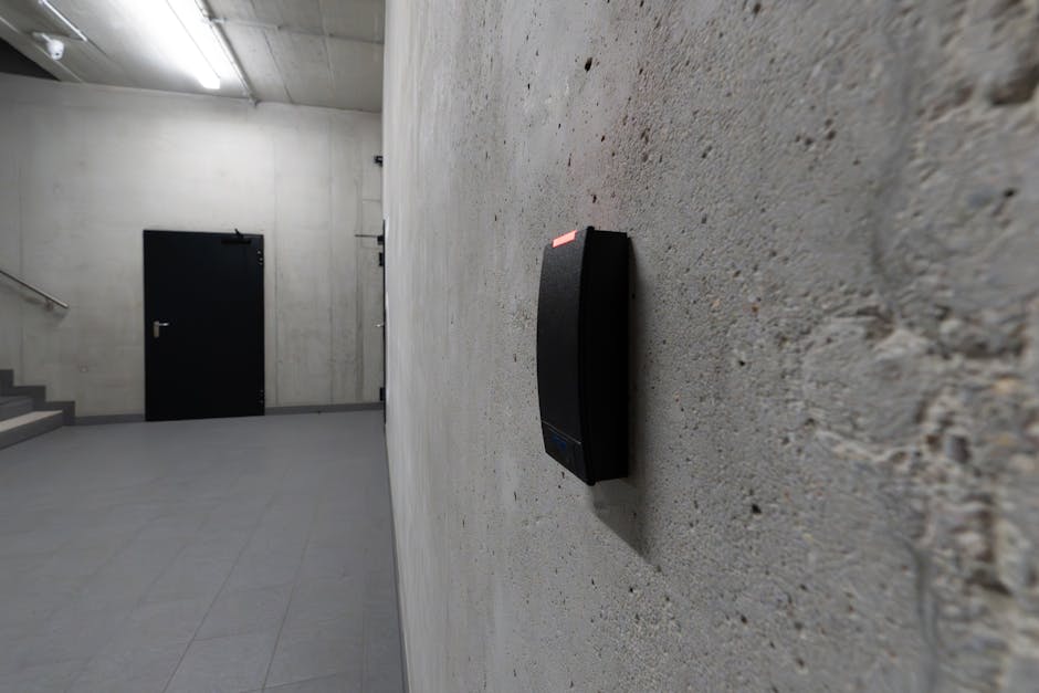 A smart electronic access terminal mounted on a concrete wall in an industrial interior for enhanced security.